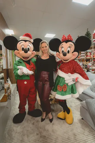 Luciane Nunes de Freitas dos Santos ladeada pelo Mickey e Minie Noel