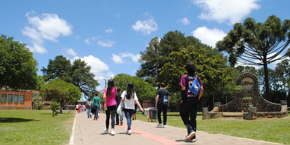 Alunos caminham em campus de universidade