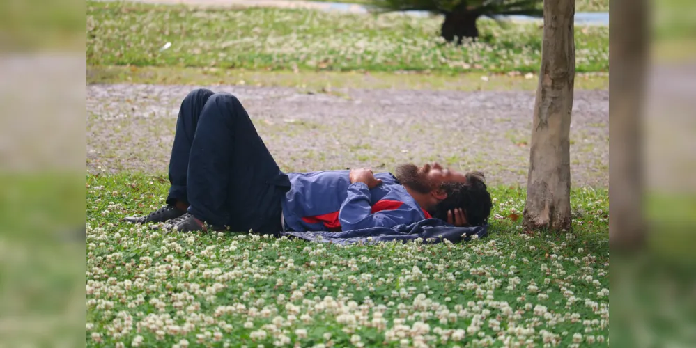 Morador em situação de rua deitado nas proximidades do Parque Ambiental.